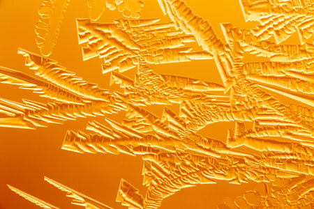 Gold patterns from frost on glass as a background. Close-up