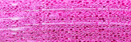 Water drops on pink glass as an abstract background. Close-upの写真素材