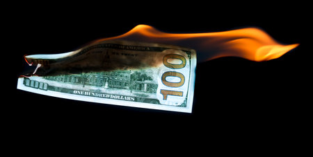 One Hundred Dollars are burning on a black background.の写真素材