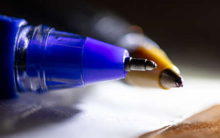 Close-up of a ballpoint pen on a table in the light of a lantern. Macroの写真素材