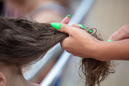 Weaving braids on the girl's head. Beauty saloonの写真素材