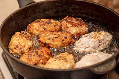Minced beef cutlets are fried in a pan. Close-upの写真素材