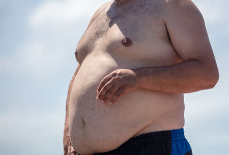 A fat man sunbathes in the sun.の写真素材