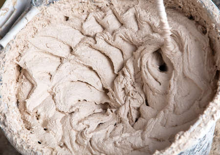 A worker kneads the mixture into plaster buckets.