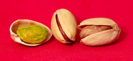 Close-up of fresh pistachio nuts on a red background. Macro