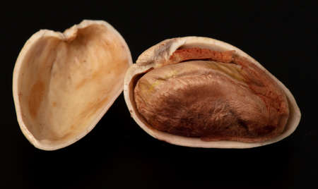 Close-up of fresh pistachio nuts on a black background. Macro