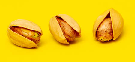 Close-up of fresh pistachio nuts on a yellow background. Macro