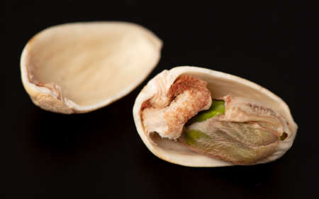 Close-up of fresh pistachio nuts on a black background. Macro