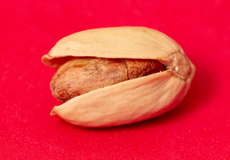 Close-up of fresh pistachio nuts on a red background. Macro