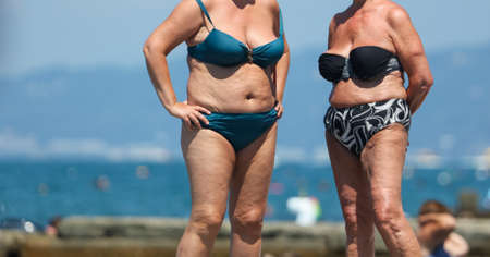 Two old women in bathing suits on the beach.の写真素材