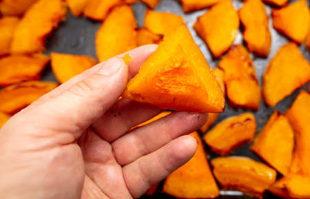 Oven baked pumpkin in a man's hand. Close-upの写真素材