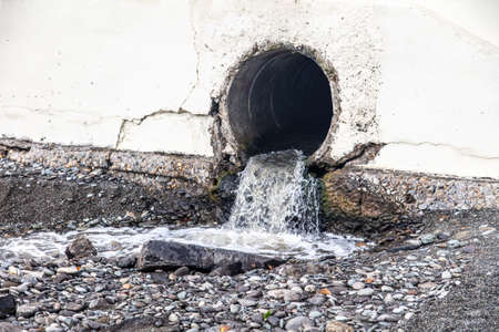 The sewer pipe leads to the pebble beach of the sea.の写真素材