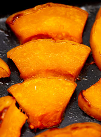 Pieces of pumpkin baked on a baking sheet.の写真素材