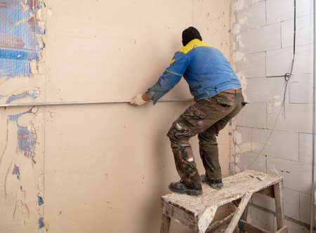 A worker plasters the walls in the room. Building a houseの写真素材