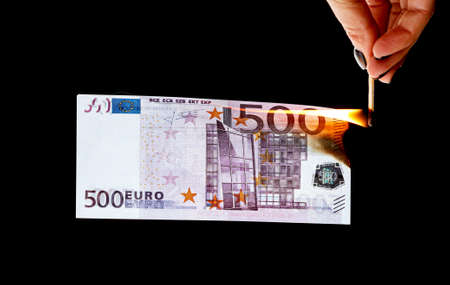 Five hundred Euros burn from a match isolated on a black background.の写真素材