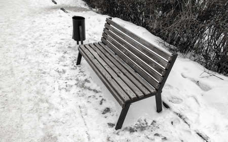 Wooden bench in the snow in the park.