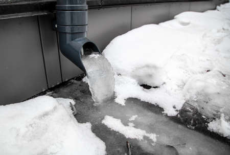 Ice in the drain pipe against the wall of the house.の写真素材