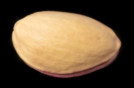 Close-up of fresh pistachio nuts on a black background. Macro