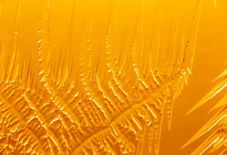 Gold patterns from frost on glass as a background. Close-up
