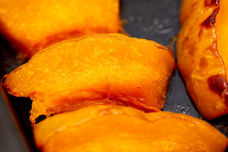 Pieces of pumpkin baked on a baking sheet.の写真素材