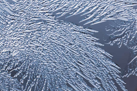 Blue patterns from frost on glass as a background. Close-up
