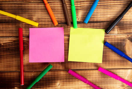 Papers and colored felt-tip pens on a wooden background. For your textの写真素材