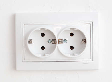 Installing a socket in a white wall. Home renovation