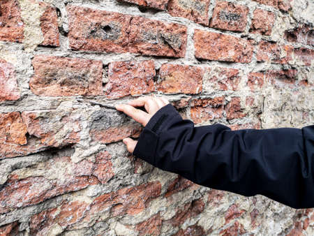 Hand on an old crumbling brick wall.の写真素材