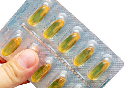 Yellow transparent pill of fish oil in hand.