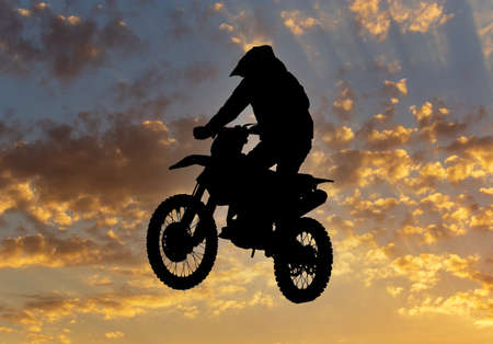 Silhouette of a man on a motorcycle against the backdrop of the sunset.