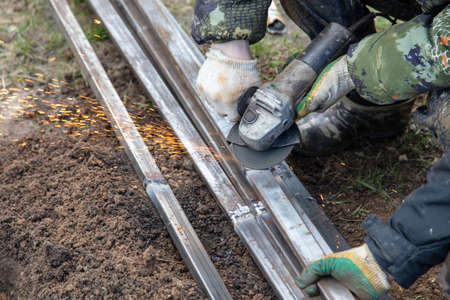 A worker grinds metal at a construction site. Technologies