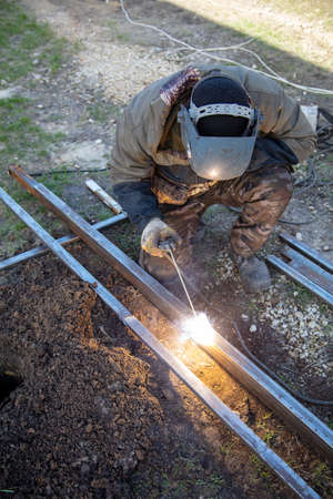 A welder welds metal at a construction site. Technologies