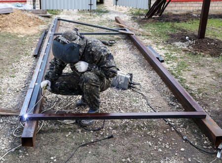 Workers weld metal for sliding gates. Technologies