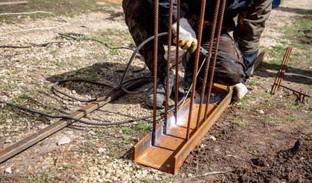 A welder welds metal at a construction site. Technologies