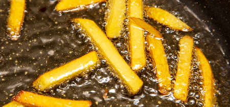 French fries are fried in oil in a pan. Close-upの写真素材