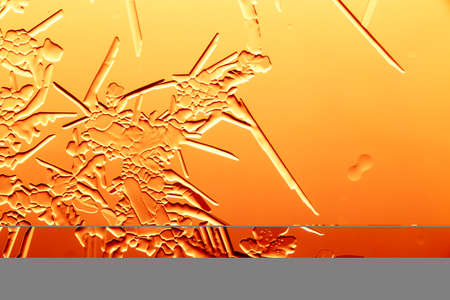 Gold patterns from frost on glass as a background. Close-up