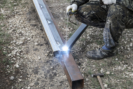 Workers weld metal for sliding gates. Technologies