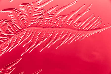 Red patterns from frost on glass as a background. Close-up