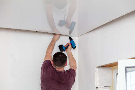 The technology of stretching the stretch ceiling in the room. Home renovationの写真素材