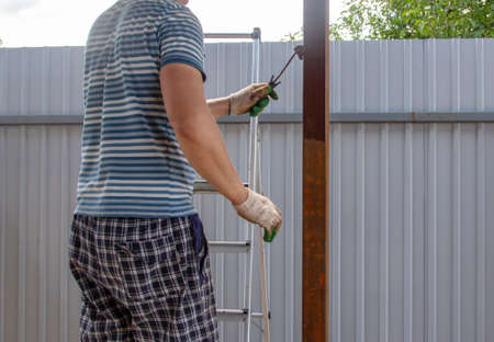 A worker paints metal on a canopy. Constructionの写真素材