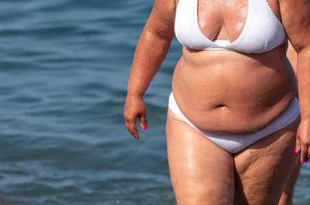 Fat woman in a swimsuit at the sea.の写真素材