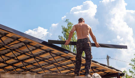 Workers install a metal shed on a wooden frame. Constructionの写真素材