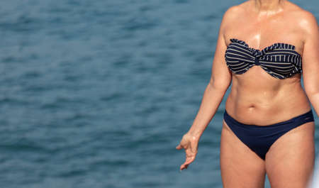 Girl in a swimsuit on the beach by the sea.の写真素材