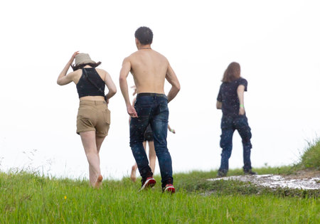 People in the rain on a dirt road in nature.の写真素材