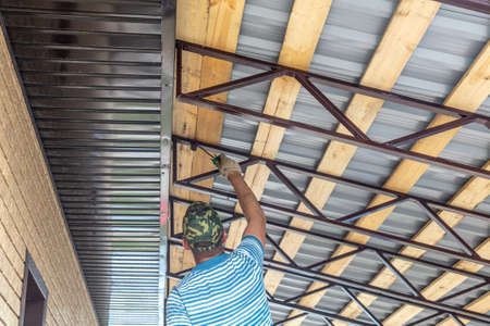 A worker paints metal on a canopy. Constructionの写真素材