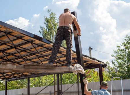 Workers install a metal shed on a wooden frame. Constructionの写真素材