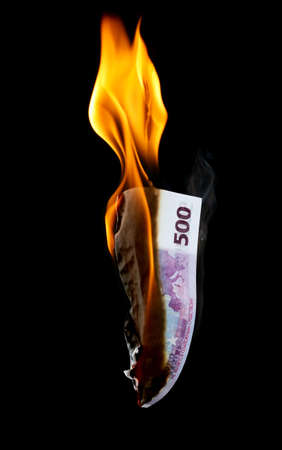 Five hundred Euros are burning with fire isolated on black background.の写真素材