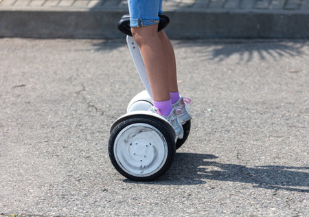 The girl is riding a gyro scooter in the park.