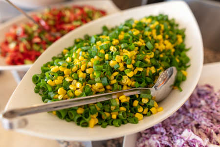 A platter of corn with vegetables in a restaurant. Close-upの写真素材