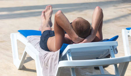 The man lies on a sun lounger by the pool.の写真素材